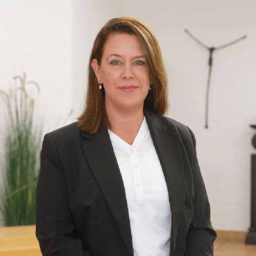 Eine Bestatterin von Vogt & Kamp Bestattungen Düsseldorf steht in modernen, hellen Räumen des Bestattungshauses in Düsseldorf.