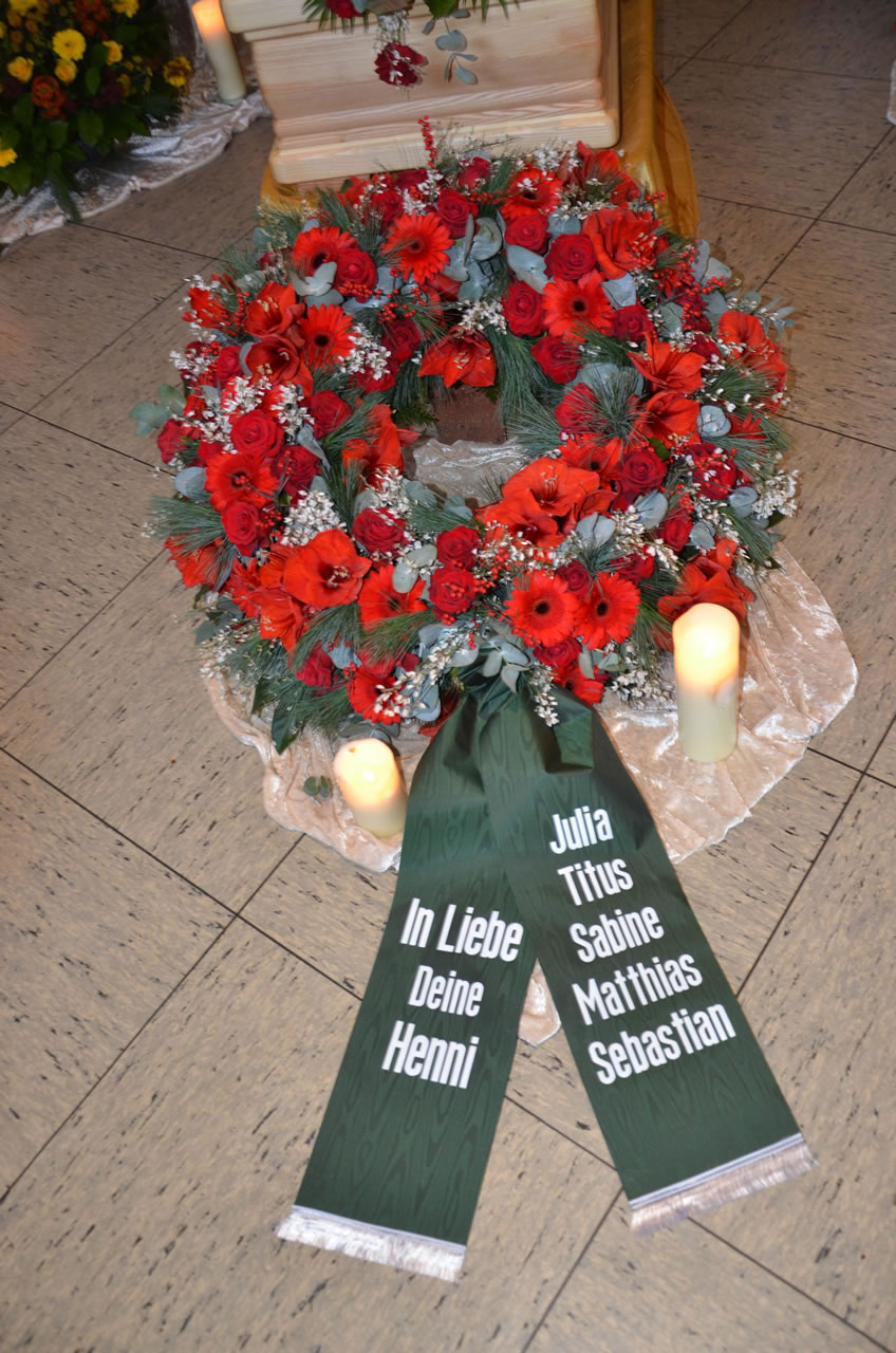 Trauerkranz mit roten Blumen, Kerzen und Schleife in der Gerricus-Kapelle - Bestatter Düsseldorf, Bestattung Düsseldorf.