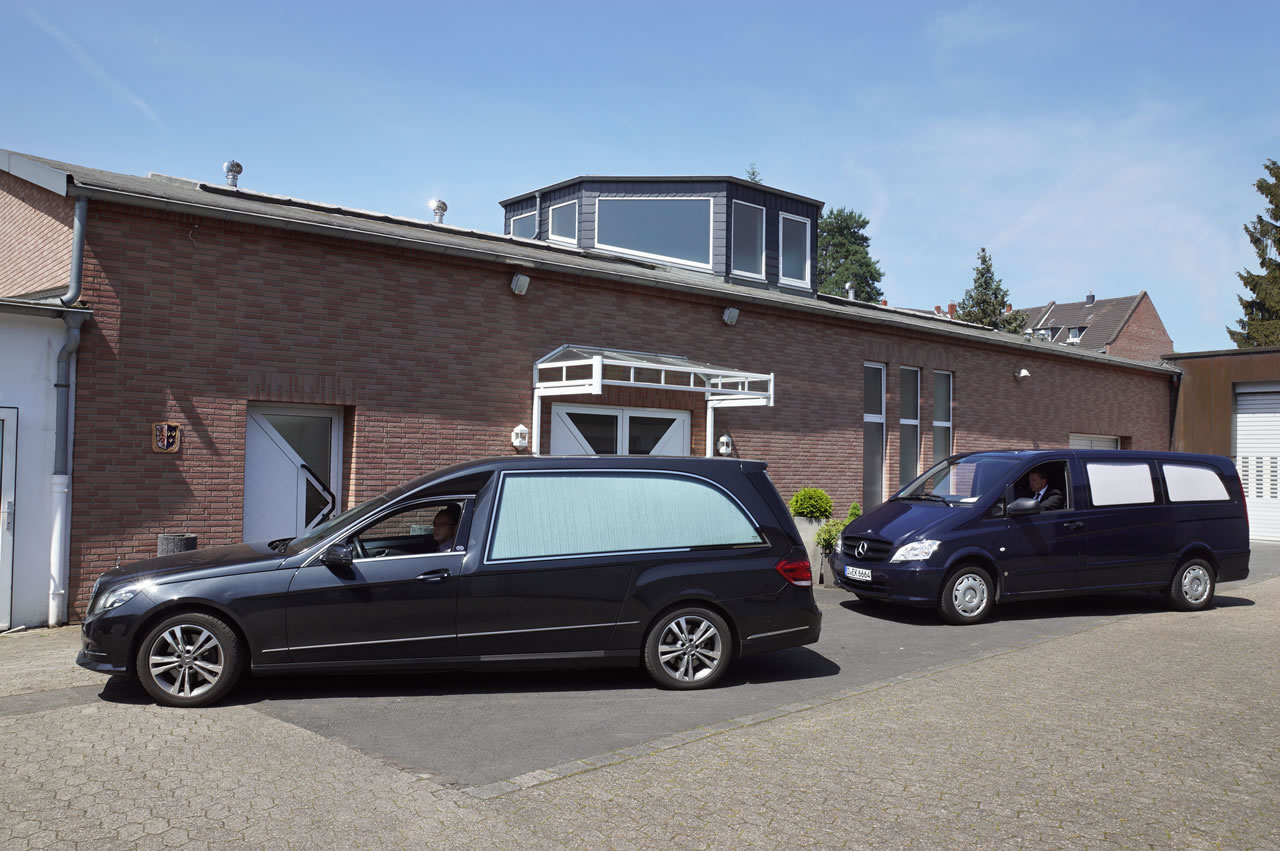 Zwei schwarze Bestattungswagen vor dem Bestattungshaus Vogt & Kamp, Ihrem Bestatter für Bestattung Düsseldorf.