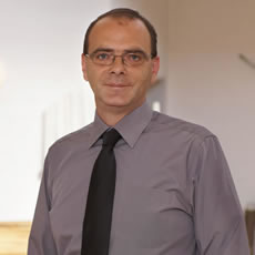 Ein Bestatter aus Düsseldorf von Vogt & Kamp steht professionell im Bestattungshaus, freundlich und seriös vor uns.