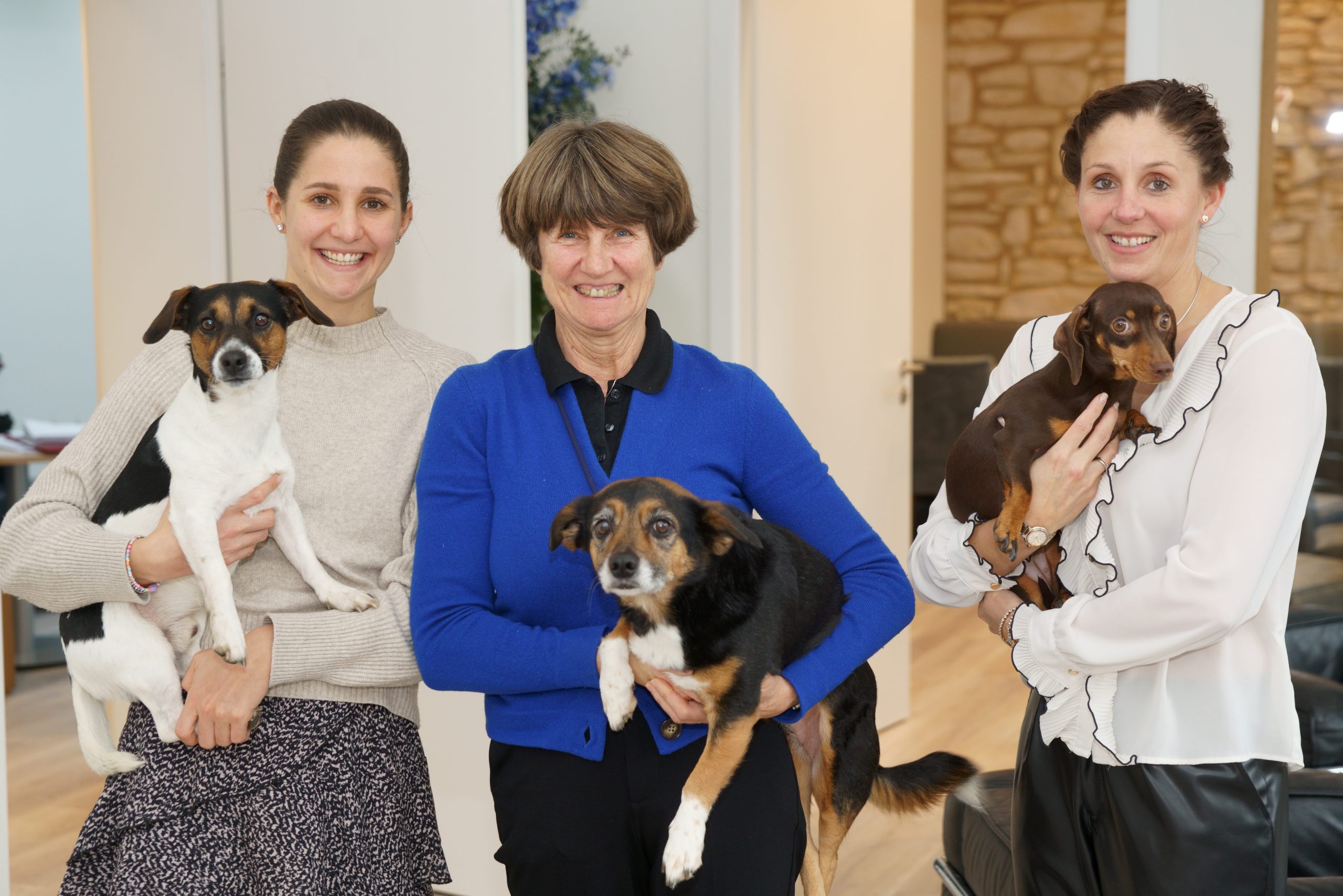 Drei Mitarbeiterinnen von Vogt & Kamp Bestattungen Düsseldorf mit Hunden, herzlich im Bestattungshaus Düsseldorf.